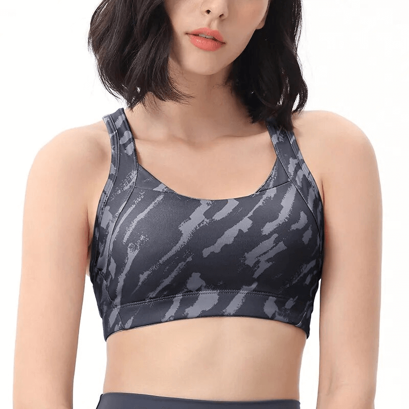 Woman wearing a stylish elastic sports bra with a cross back design in a breathable and lightweight fabric, perfect for workouts.